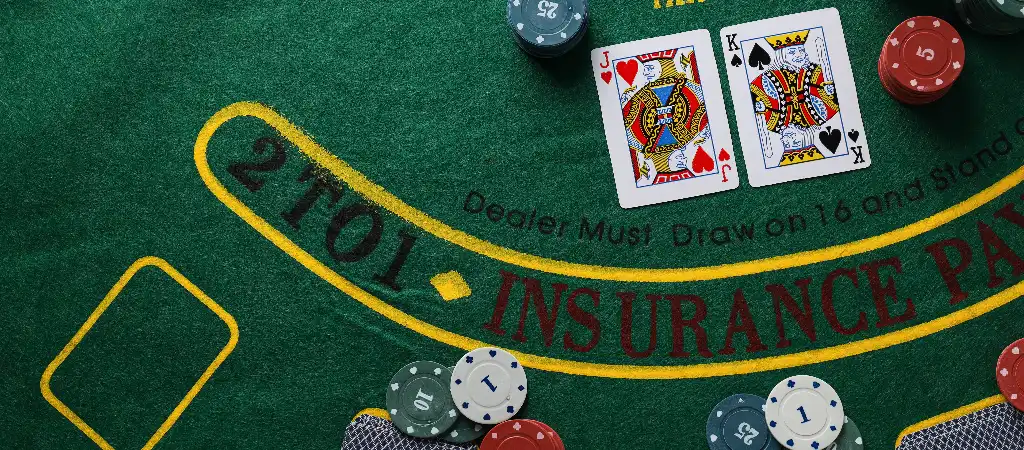 Blackjack szabályok kezdőknek, kártyák és zsetonok az asztalon, a játék alapjainak bemutatása kaszinó környezetben