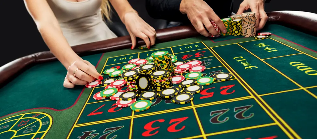 Zsetonok elhelyez&eacute;se a rulettasztalon t&ouml;bb j&aacute;t&eacute;kos r&eacute;sz&eacute;ről, amely a biztons&aacute;gos rulett strat&eacute;gia megfontolt &eacute;s kontroll&aacute;lt megk&ouml;zel&iacute;t&eacute;s&eacute;t szeml&eacute;lteti.